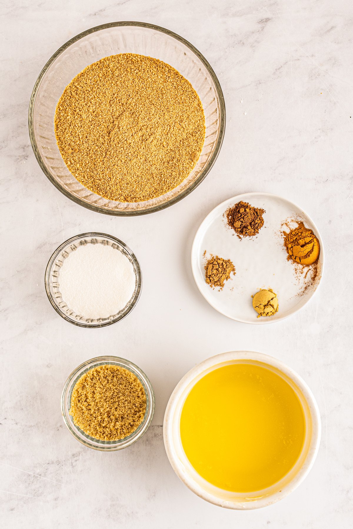 assorted prep bowls with the ingredients to make a graham cracker crust