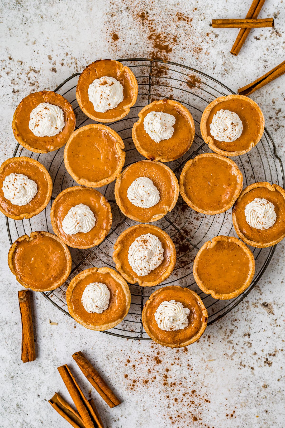 a round platter with a large assortment of miniature pumpkin pies