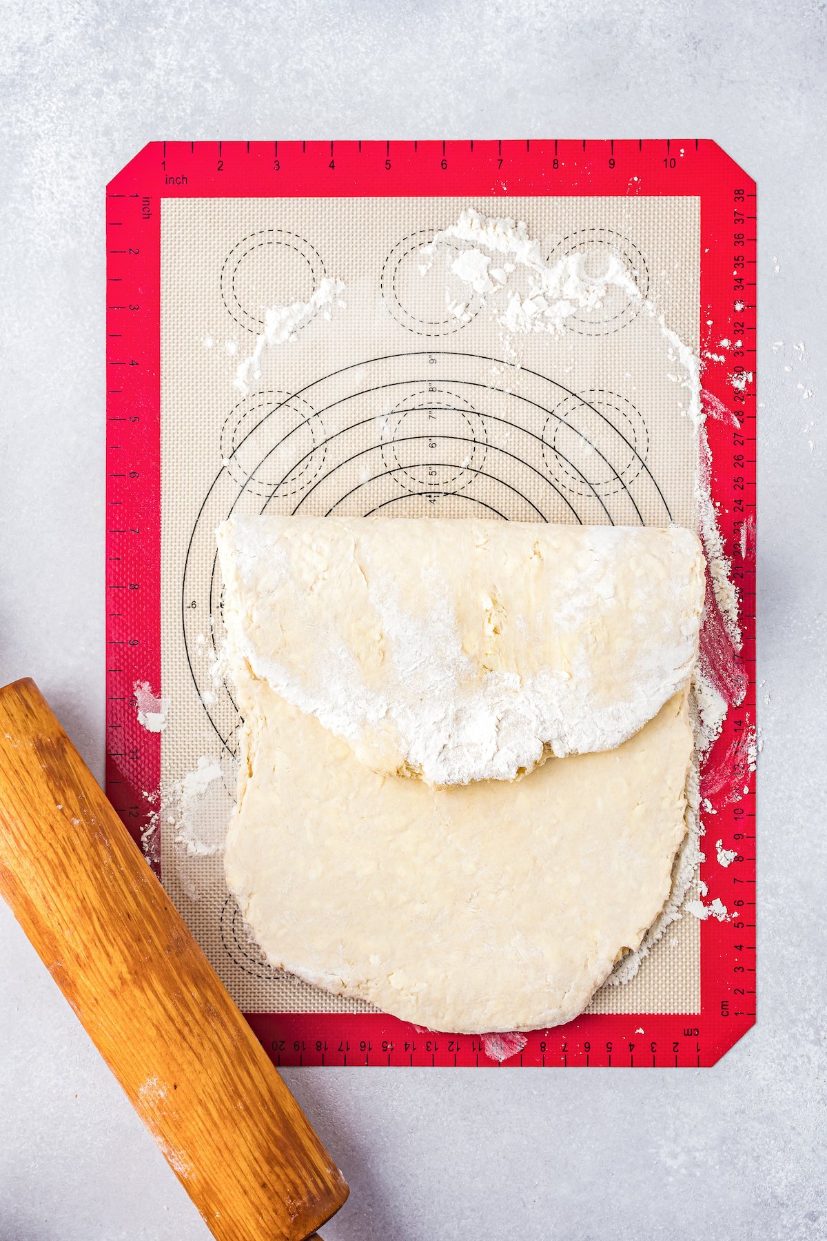 pastry dough being folded in thirds on a silicone mat