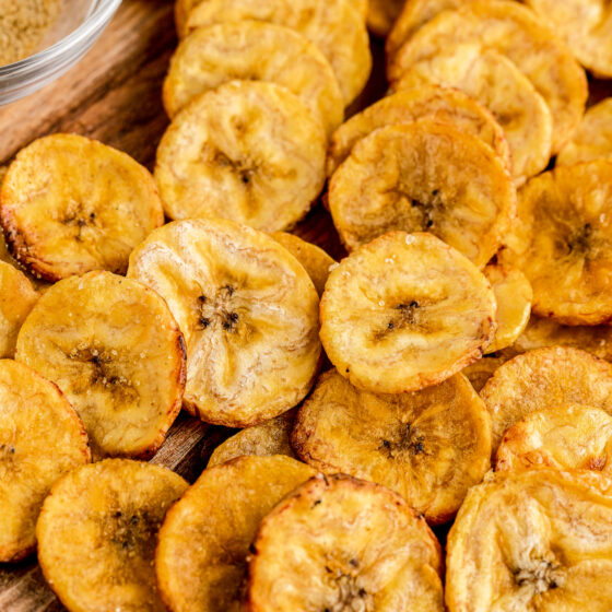 A serving of baked plantain chips on a cutting board.