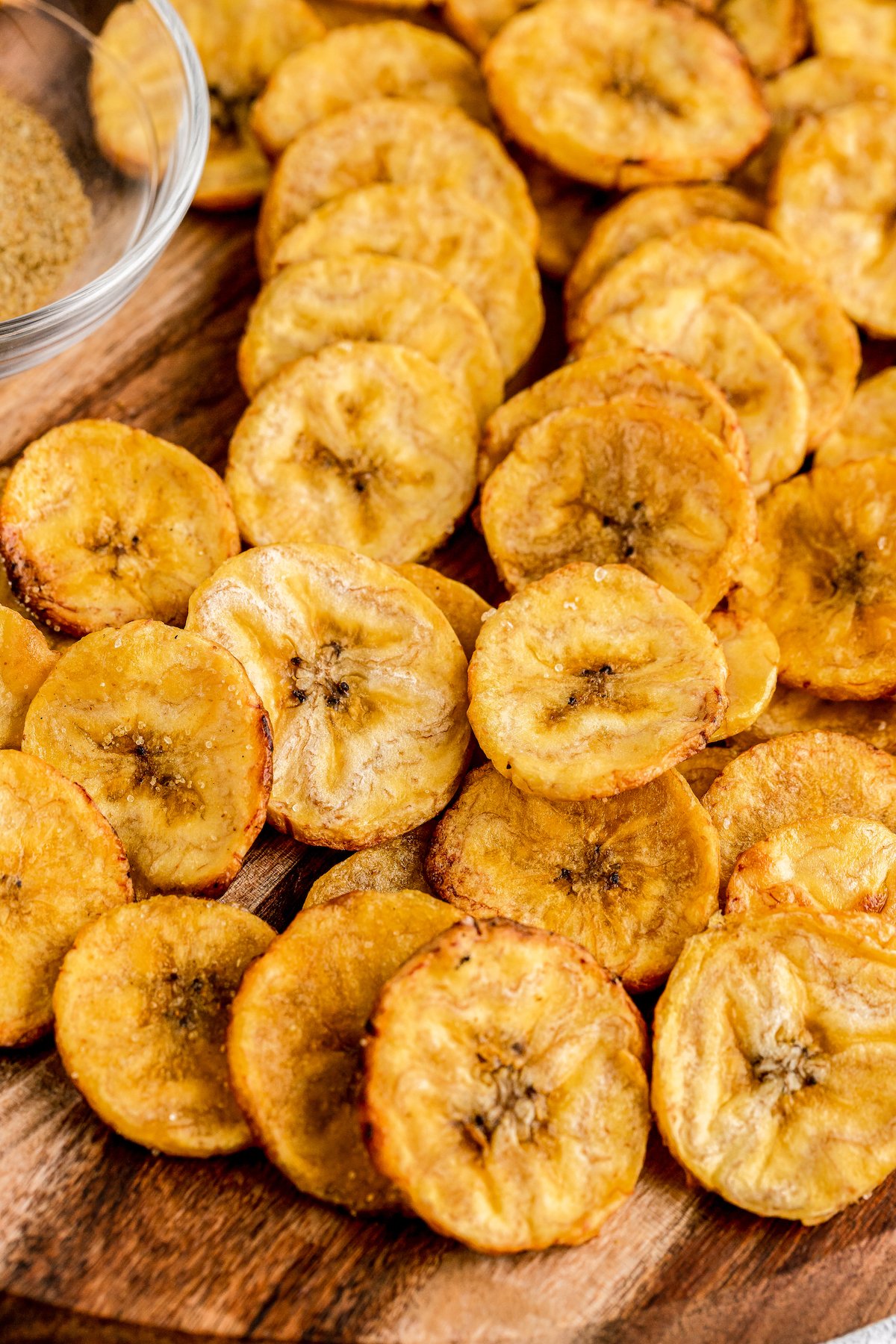 A serving of baked plantain chips on a cutting board.