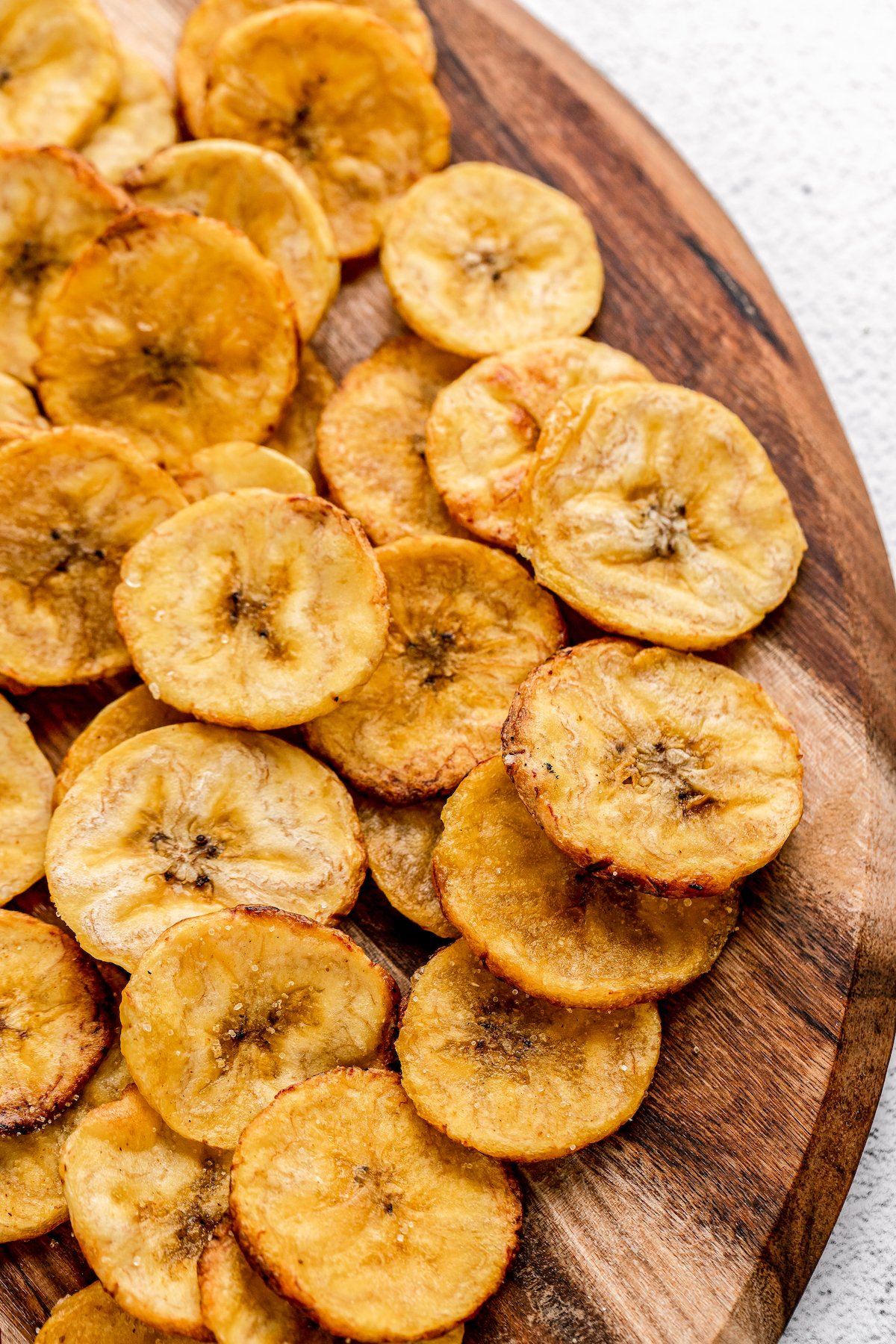 Plantain chips scattered on a cutting board.