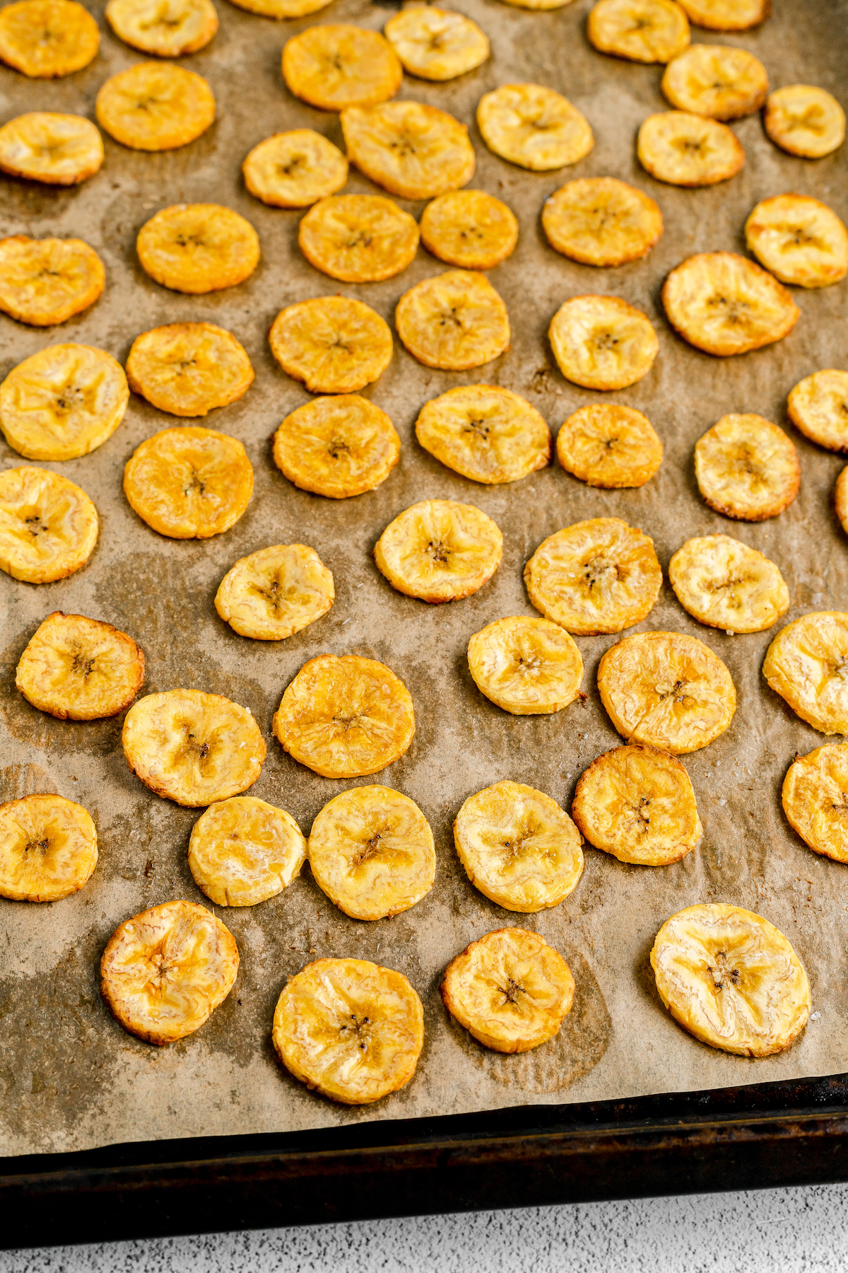 Sliced, baked plantains on a baking sheet.