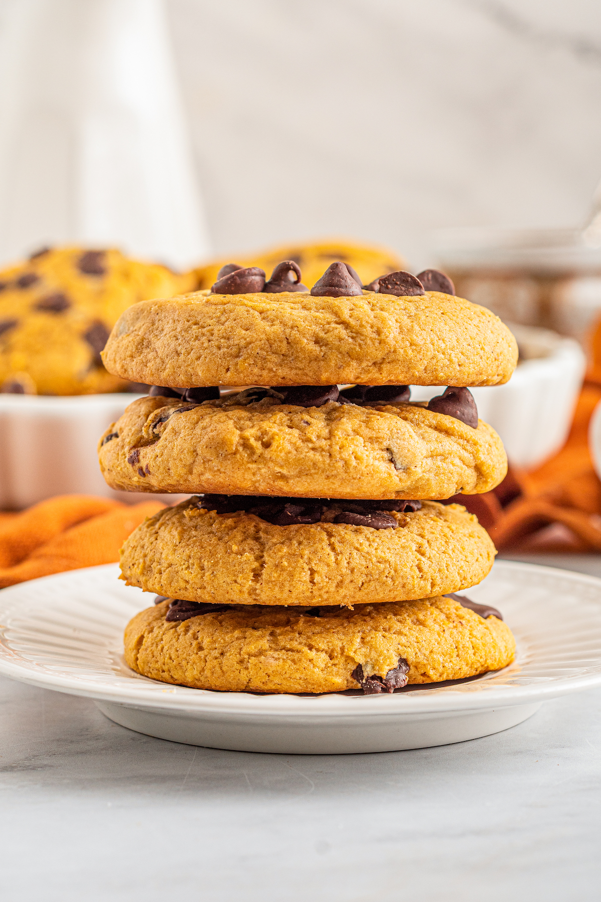 a stack of four pumpkin chocolate chip cookies