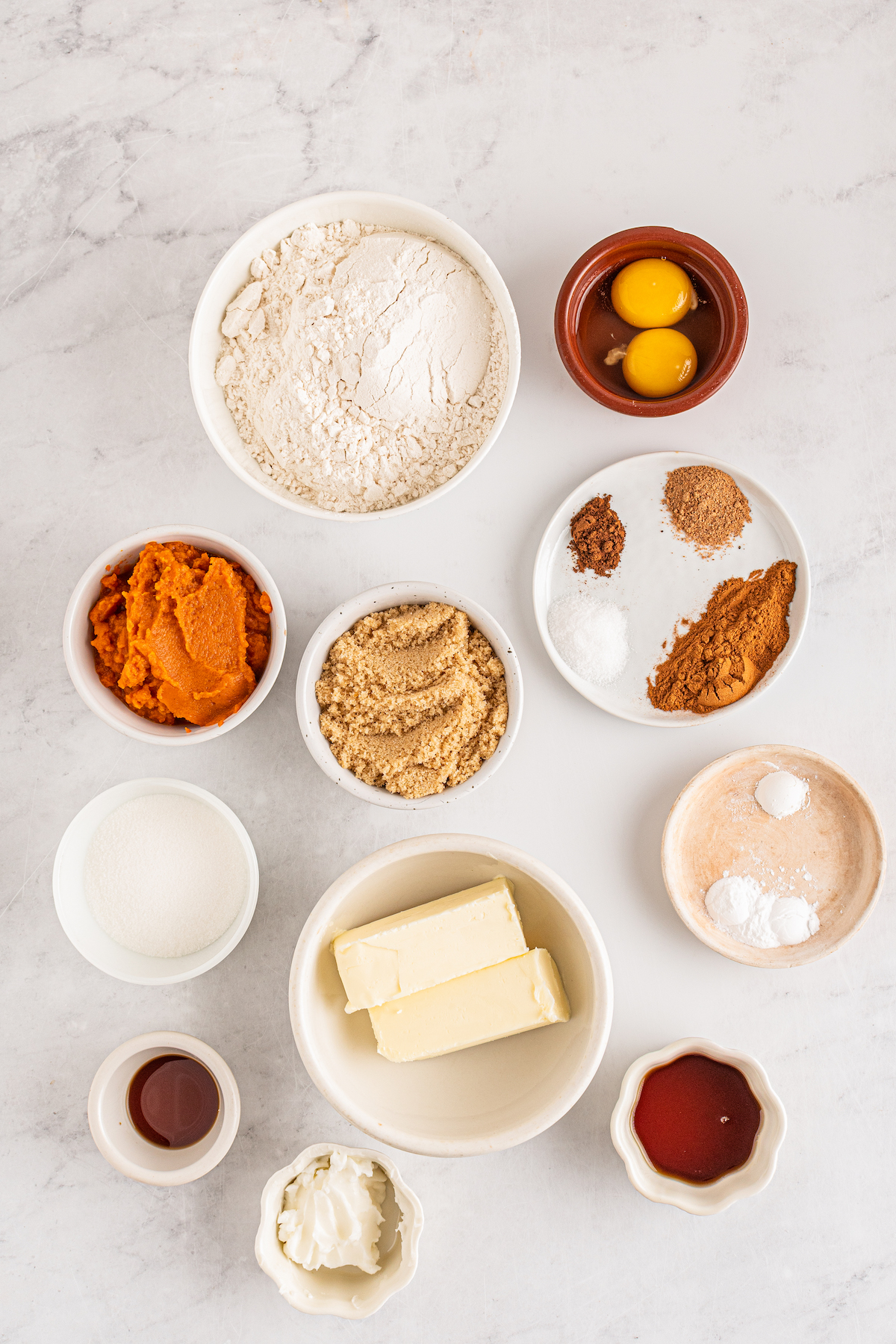 All of the ingredients for Pumpkin Cookies laid out in bowls on the counter.