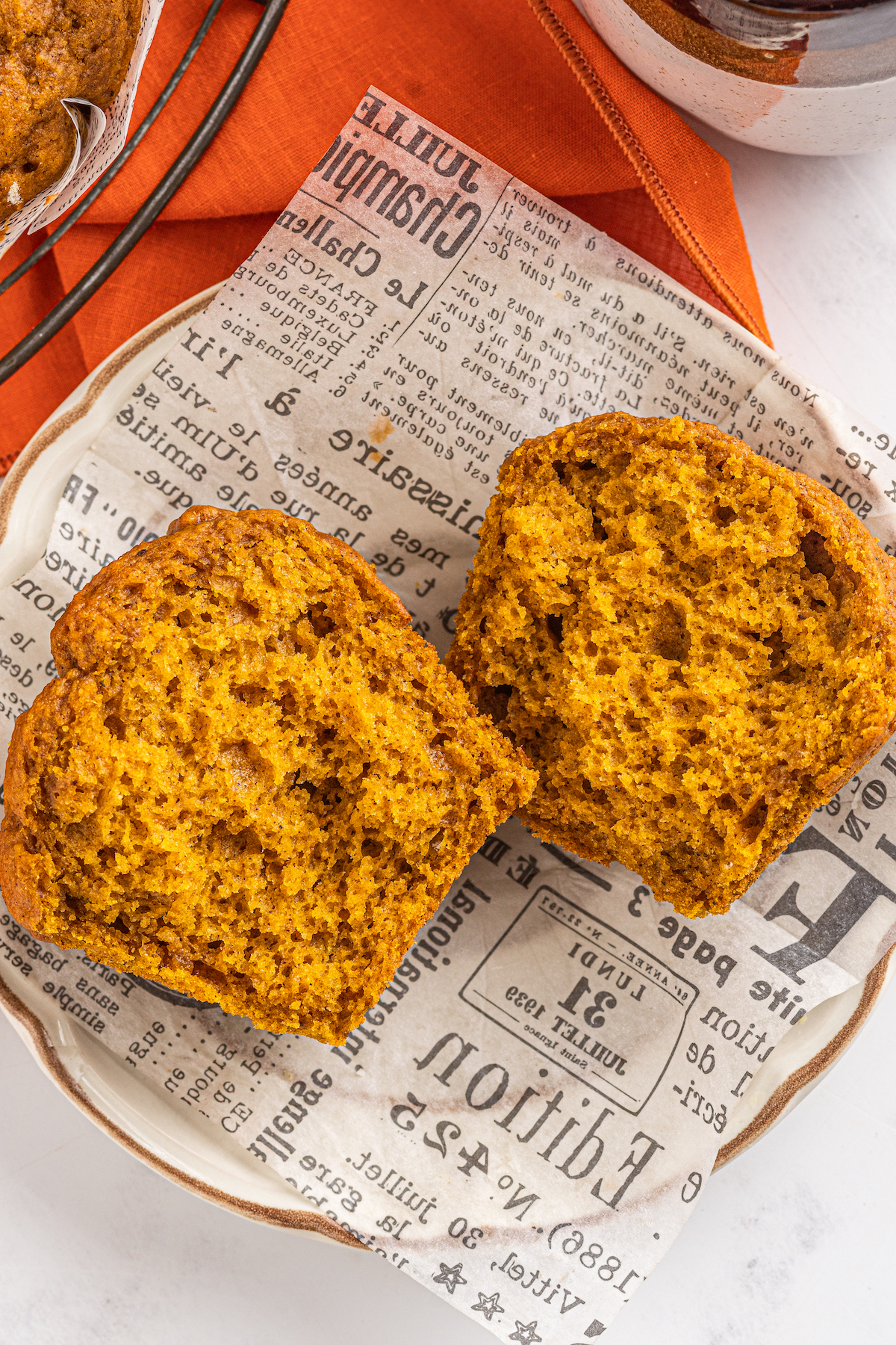 A pumpkin muffin has been split in half and presented on a wrapper.