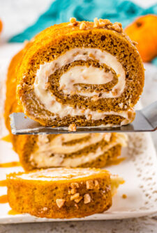 A slice of pumpkin roll cake being lifted on a serving utensil.