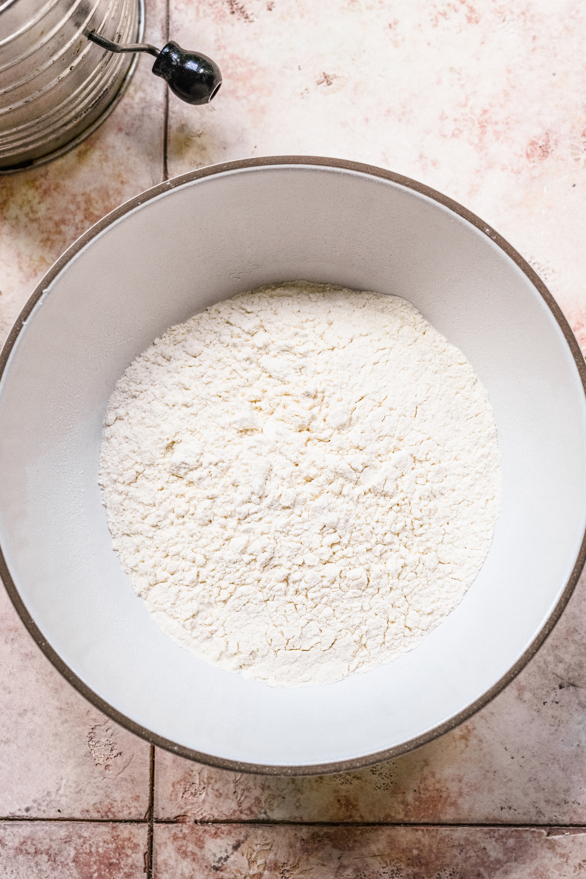 One and 1/4 cup of loose all-purpose flour spooned and leveled into a mixing bowl.