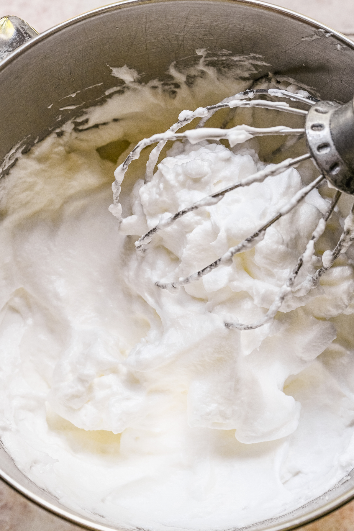 Egg whites beaten into loose peaks with the whisk attachment in the bowl.