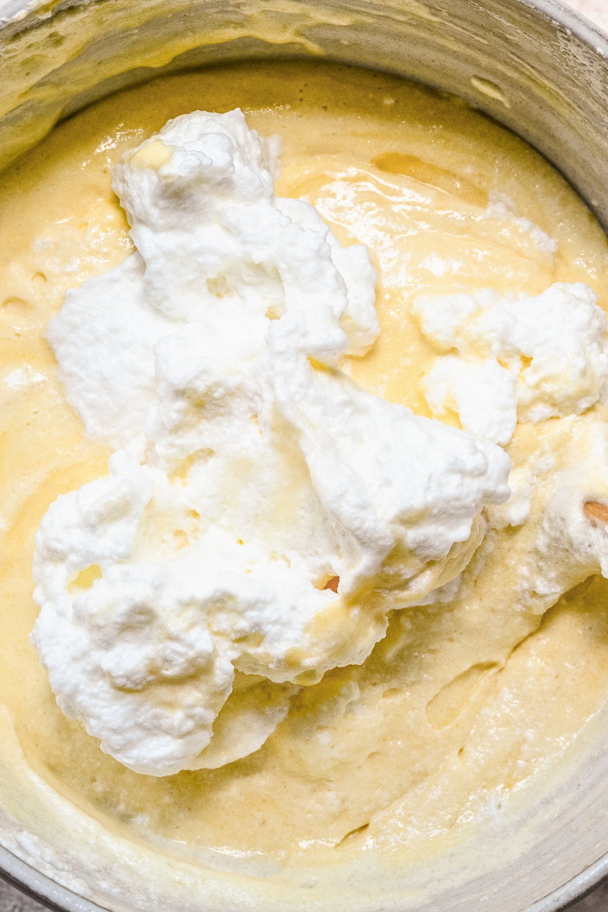 Whipped egg whites ready to be folded into vanilla cake batter.