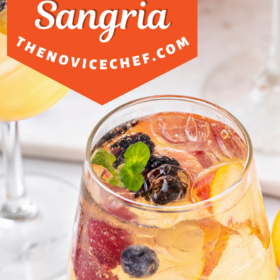 White sangria in a stemless wine glass with fresh fruit.