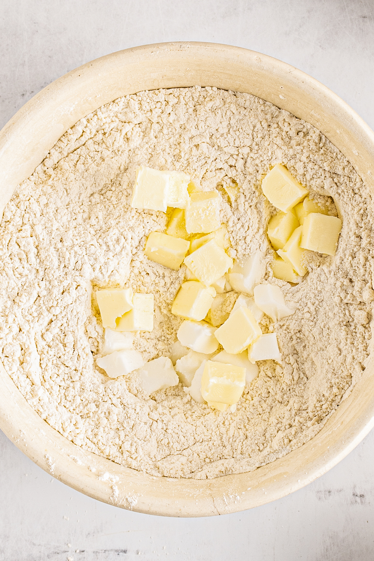 Butter and shortening in a bowl of dry baking ingredients.