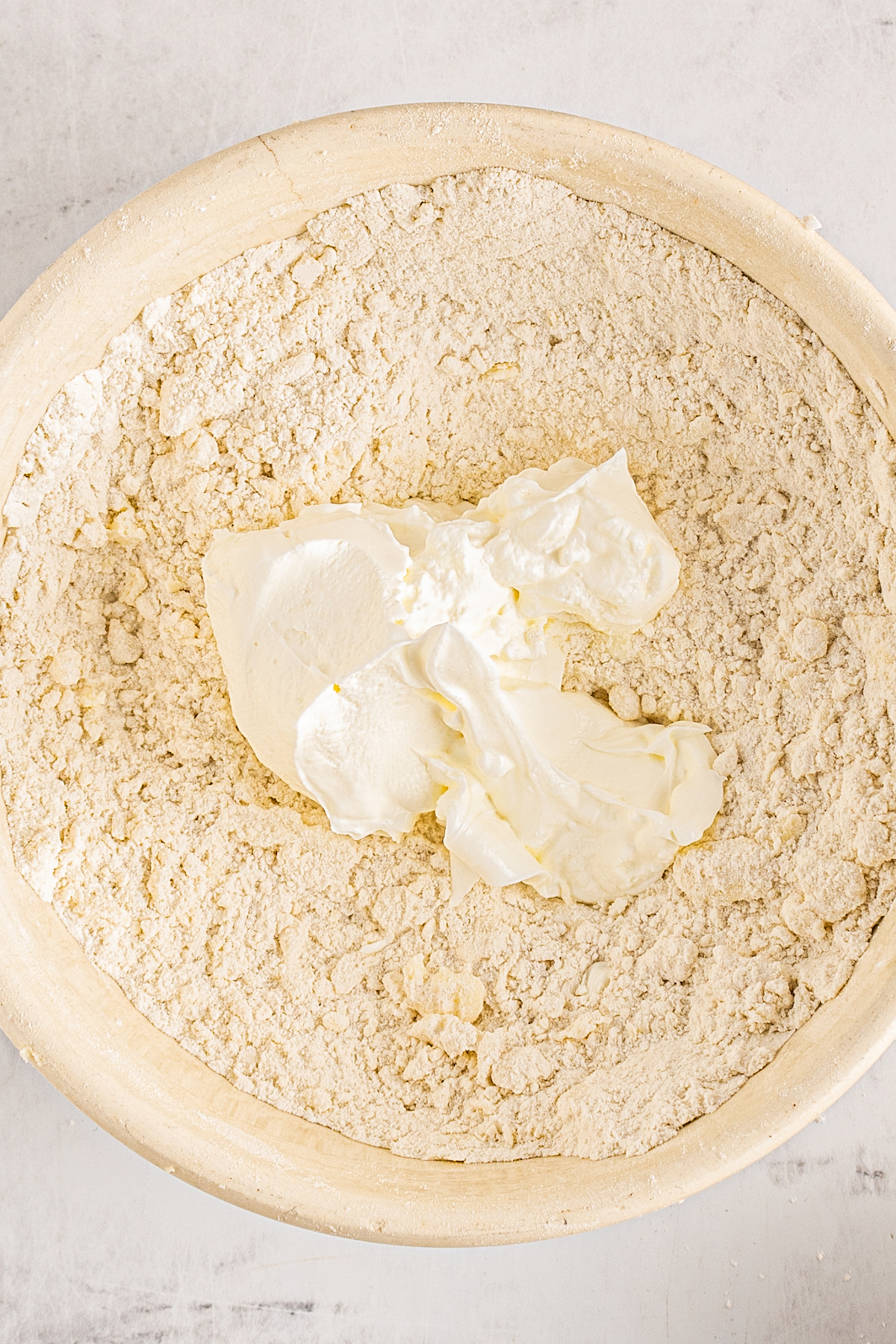 Sour cream in a bowl of dry baking ingredients.