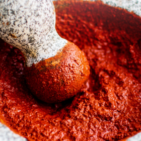 Achiote paste in a mortal and pestle.