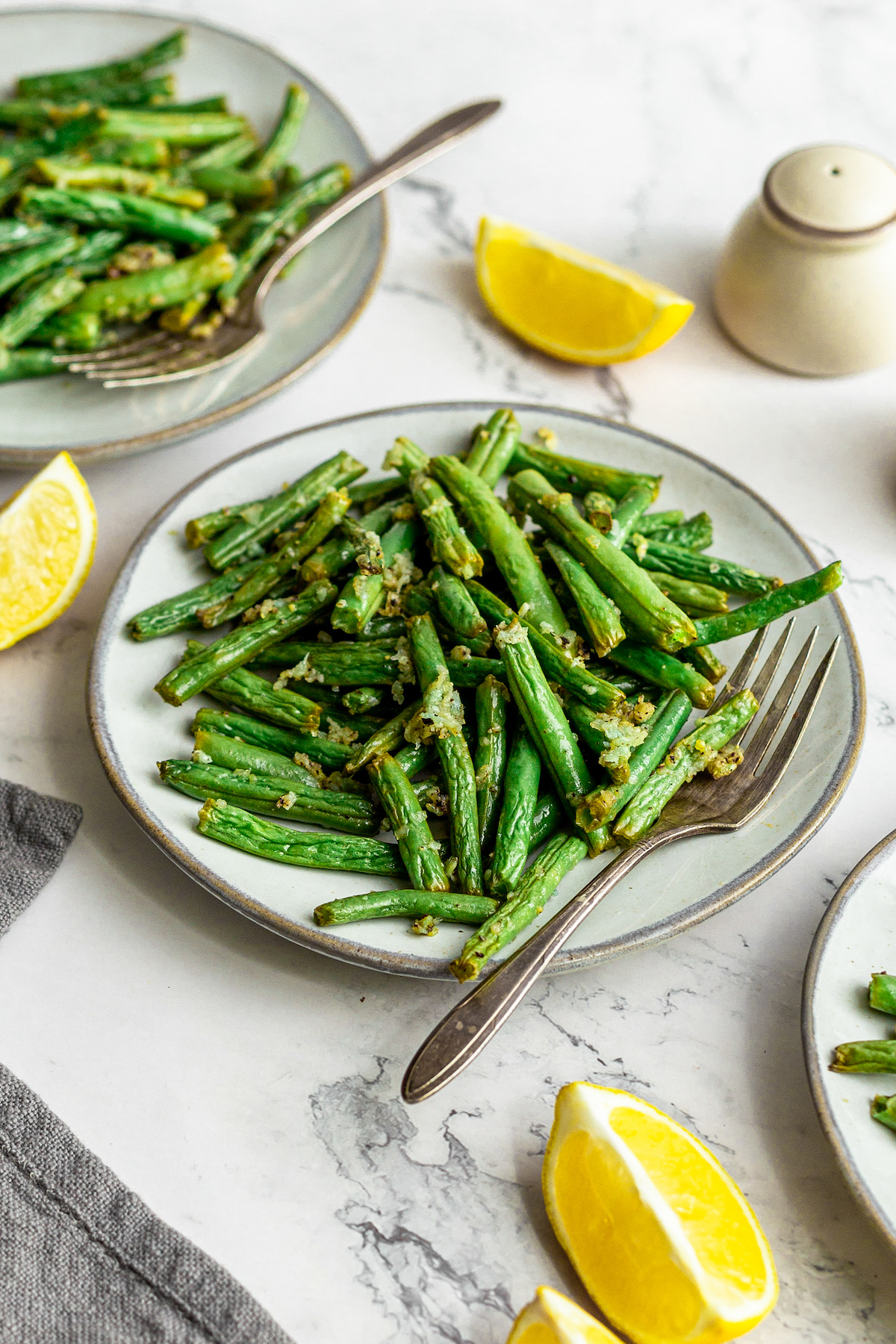 A plate of cooked green beans, wilted and lightly caramelized.