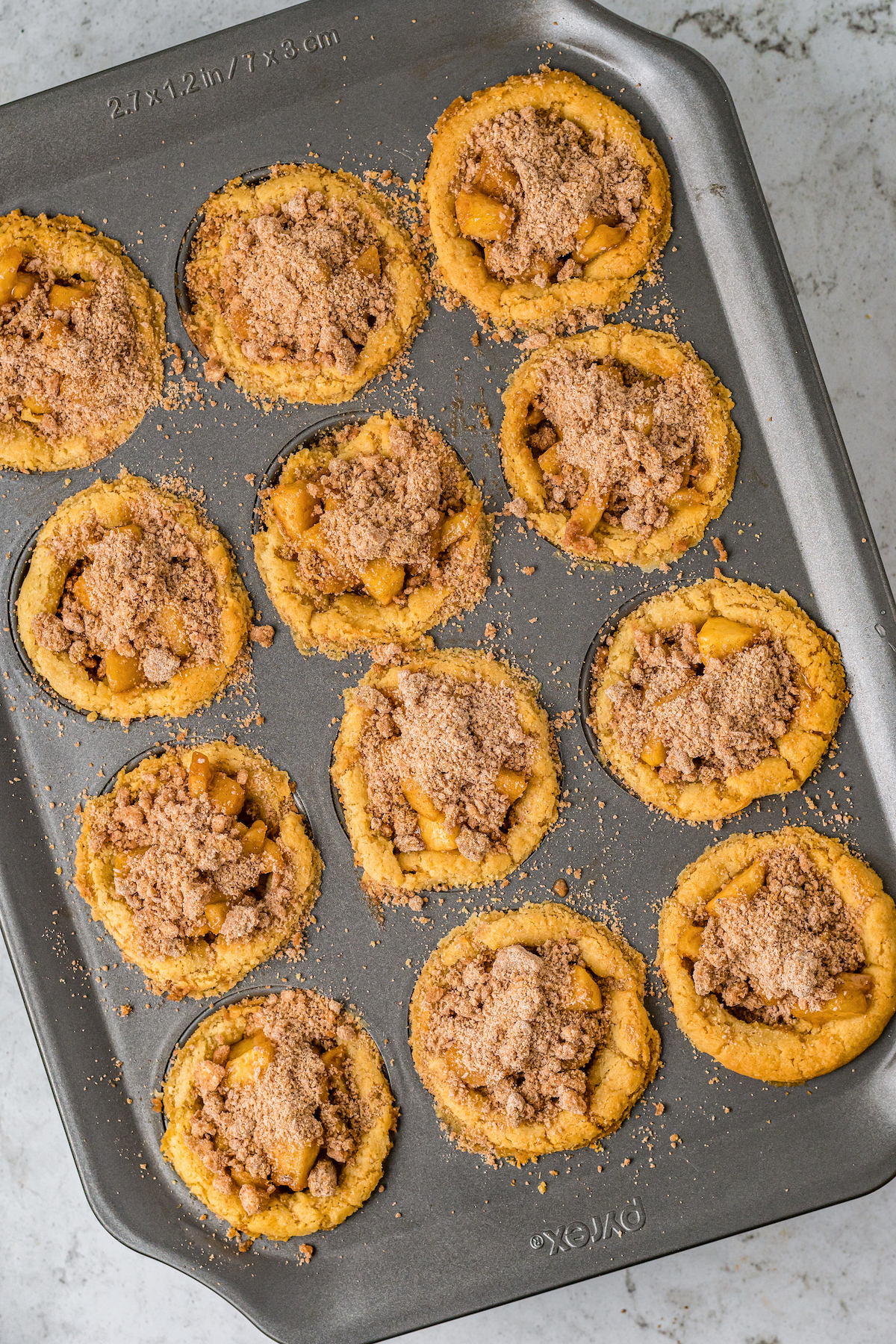 Cookie crusts filled with apple pie filling and topped with a crumb topping.