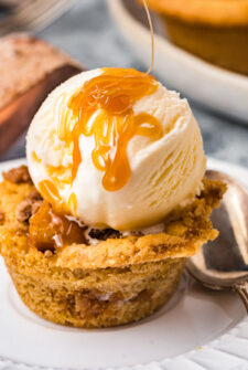 Apple pie cookie topped with ice cream and caramel sauce.