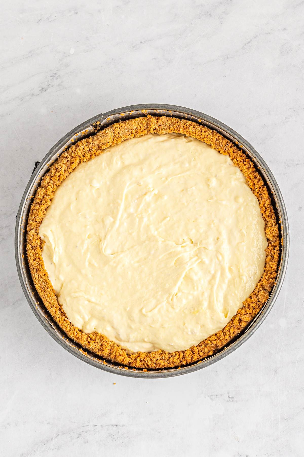 Uncooked banana pudding cheesecake in a cake pan