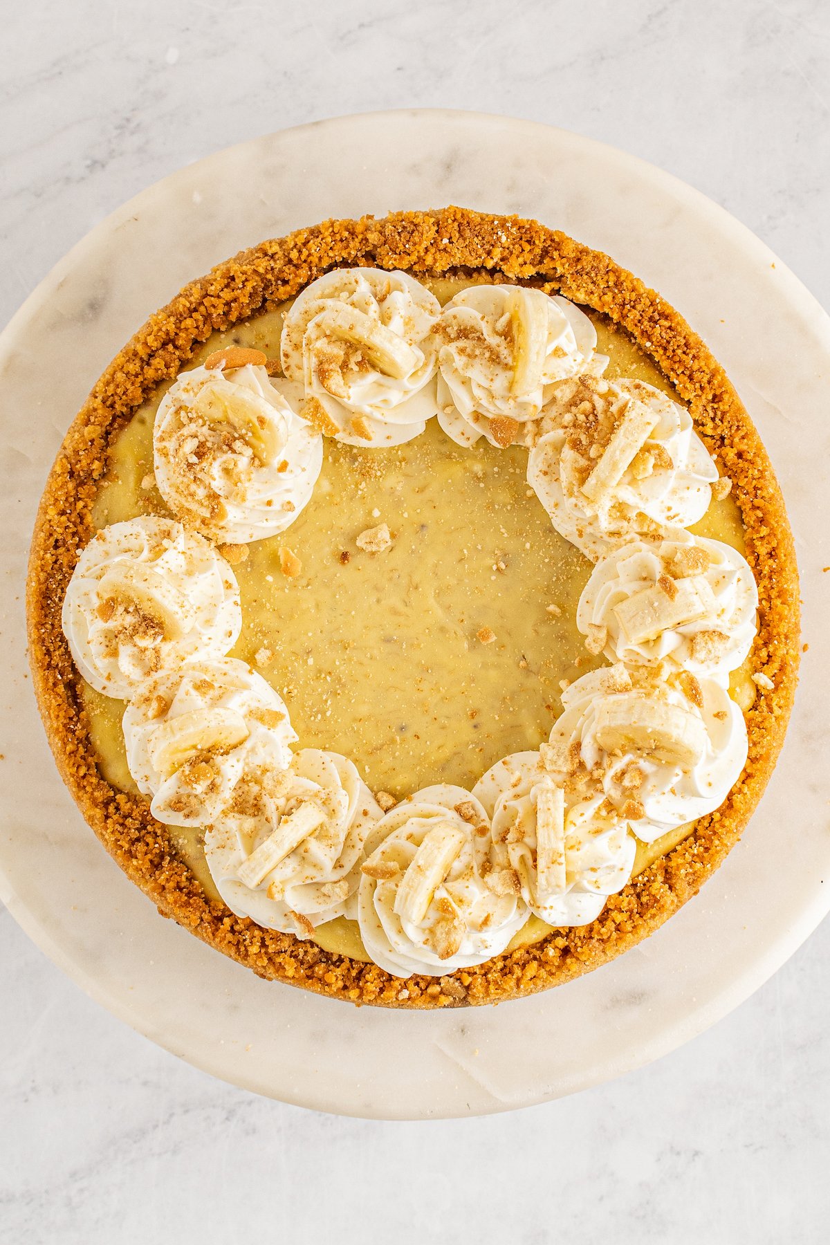Close up aerial view of a banana pudding cheesecake on a cake stand