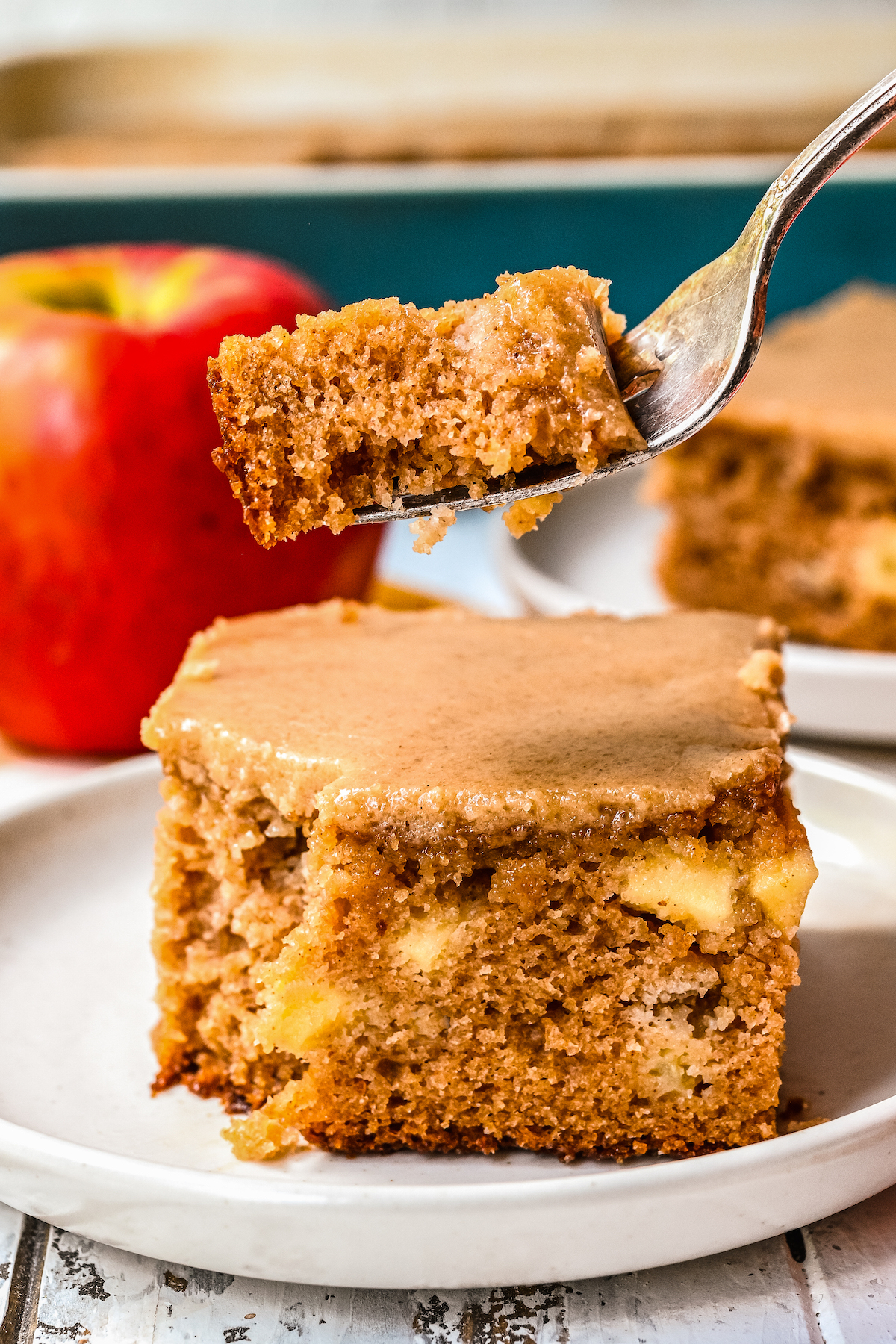 A fork taking a bite of brown sugar apple cake