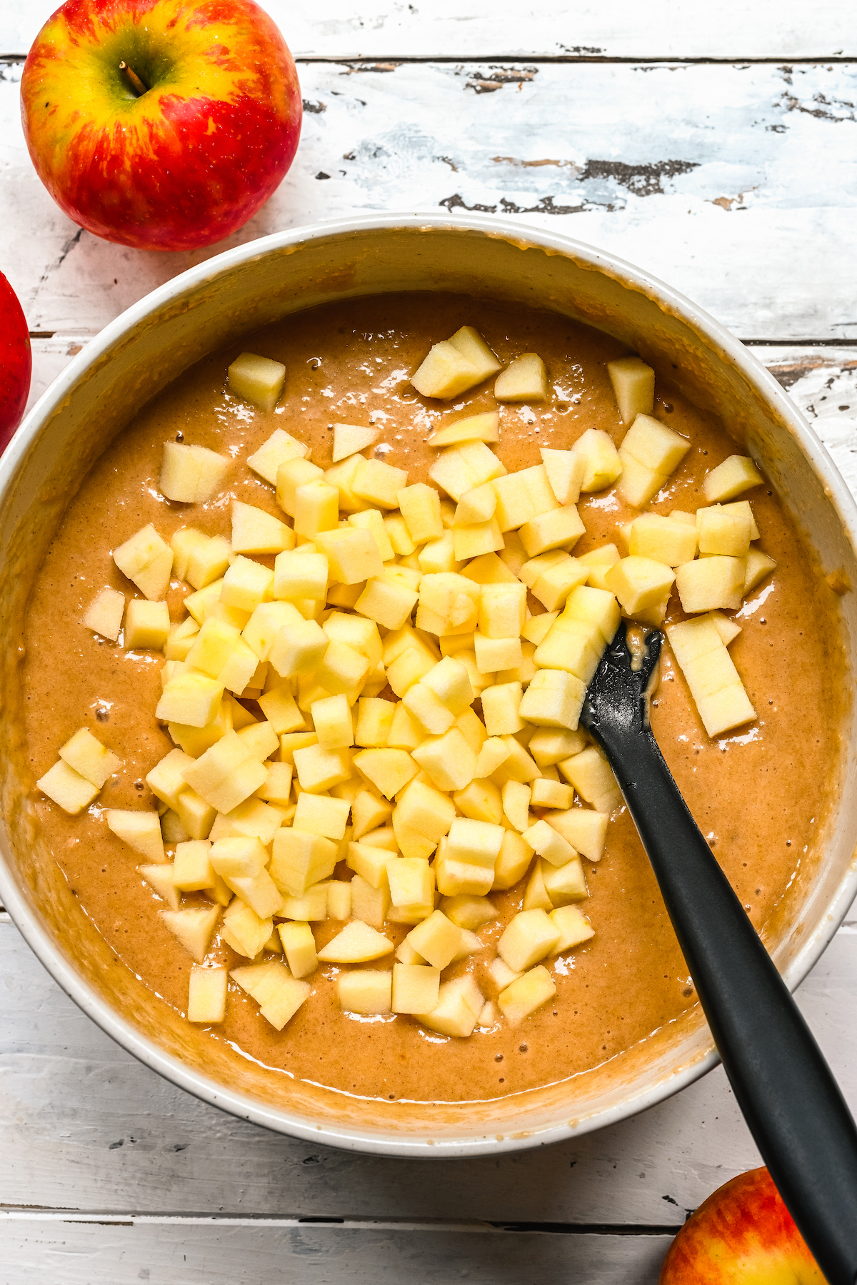 Apples being stirred into cake batter