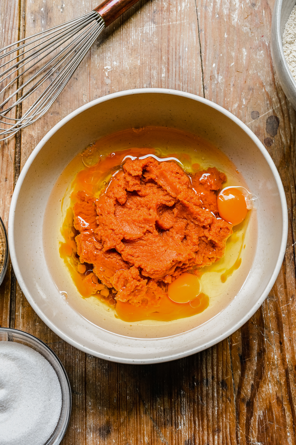 Pumpkin puree, eggs, and other ingredients in a mixing bowl.