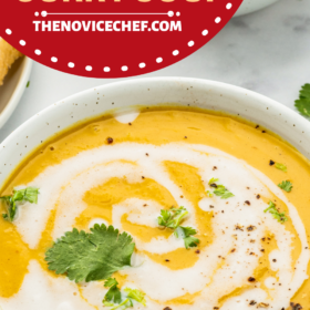 A bowl of buttternut squash soup with cream drizzled over the top, cilantro and pepper.