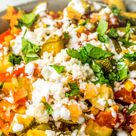 Calabacitas in a bowl with cheese and mexican creama drizzled on top.