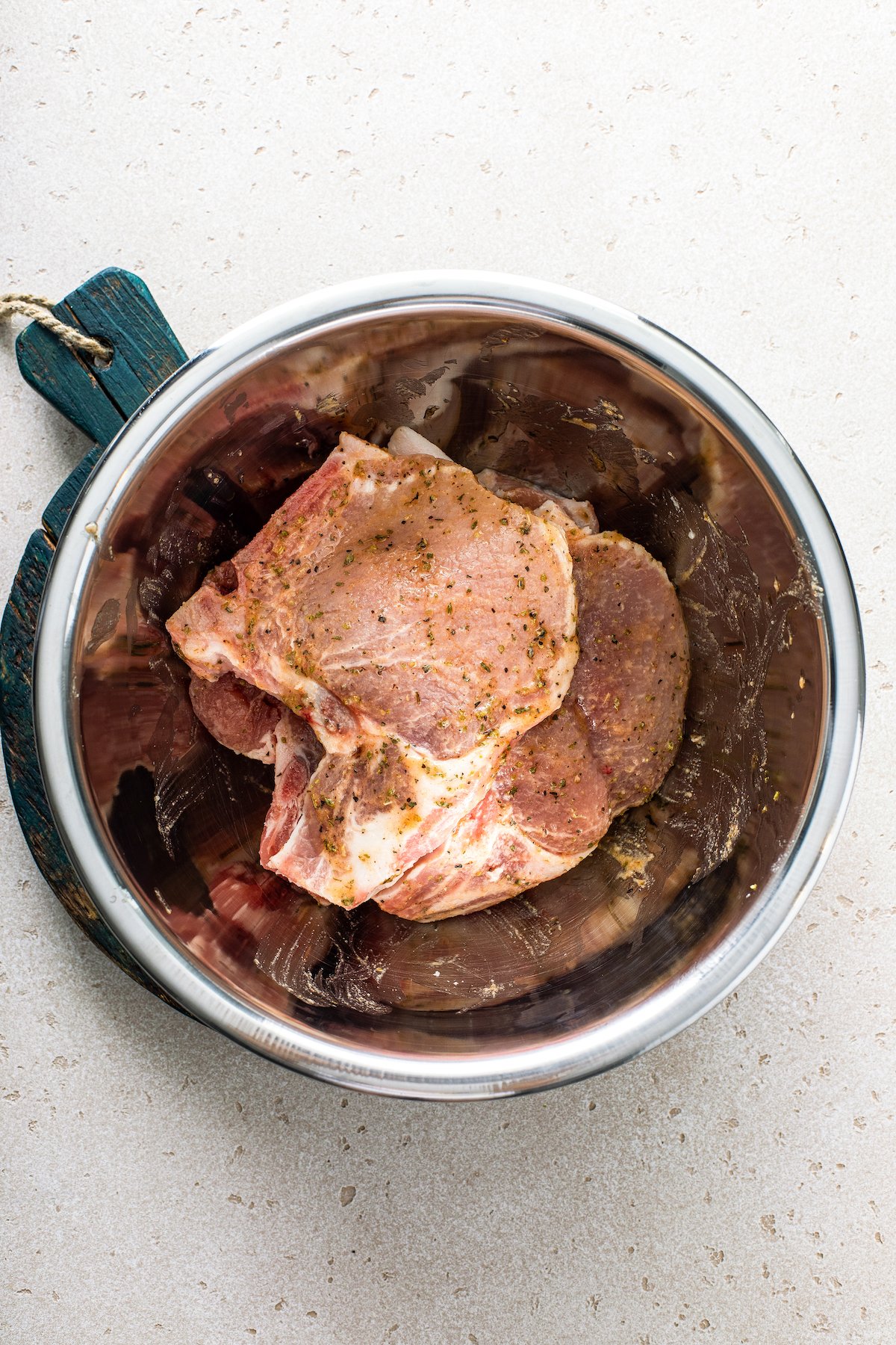 Pork chops marinating in a bowl