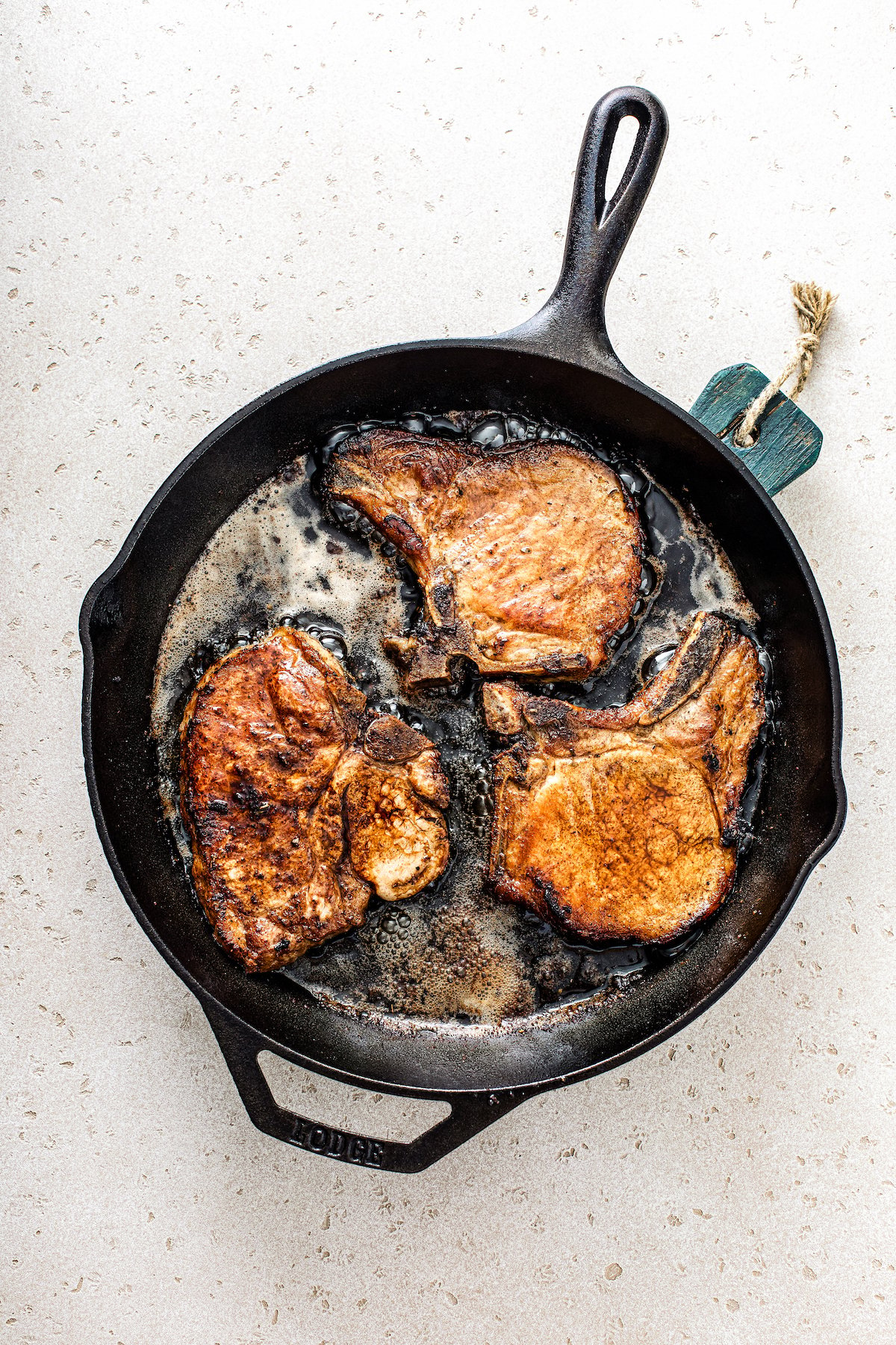 Pork chops frying in a skillet