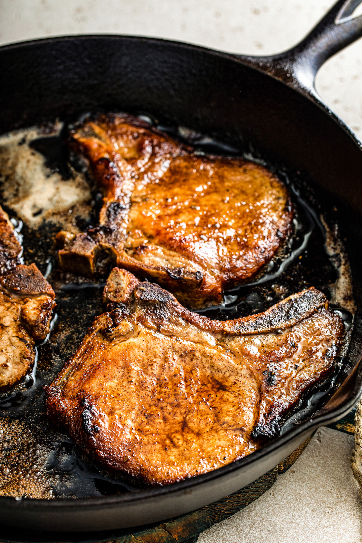 Close up of pork chops frying in a skillet
