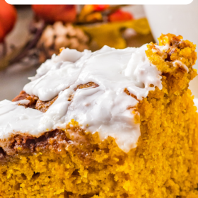 Cinnamon Roll Pumpkin Cake on a white plate with icing on top.