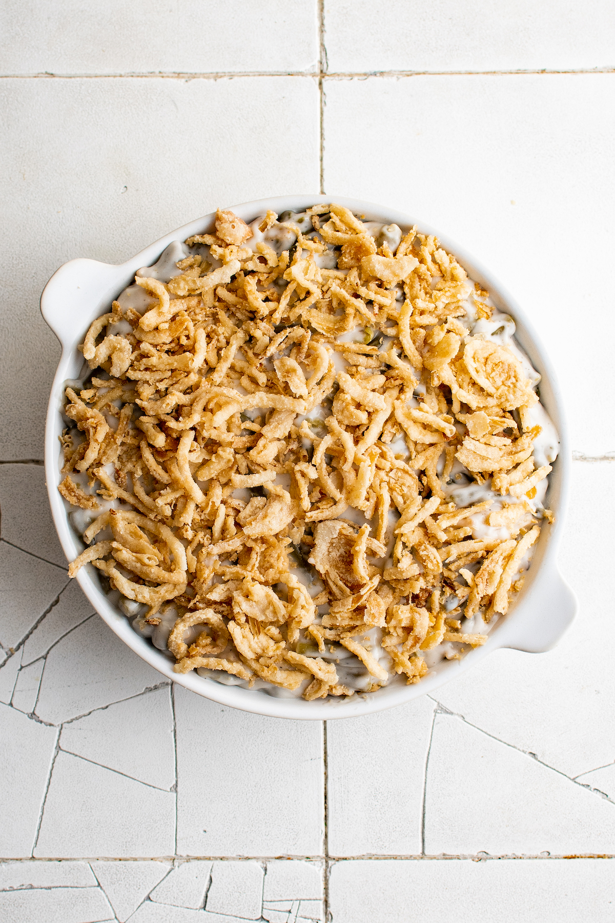 An unbaked casserole topped with fried onions.