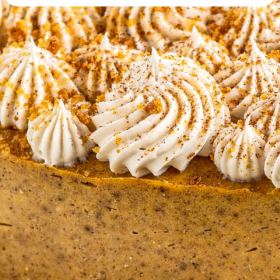 Pumpkin cheesecake with cream cheese piped on top in little swirls.