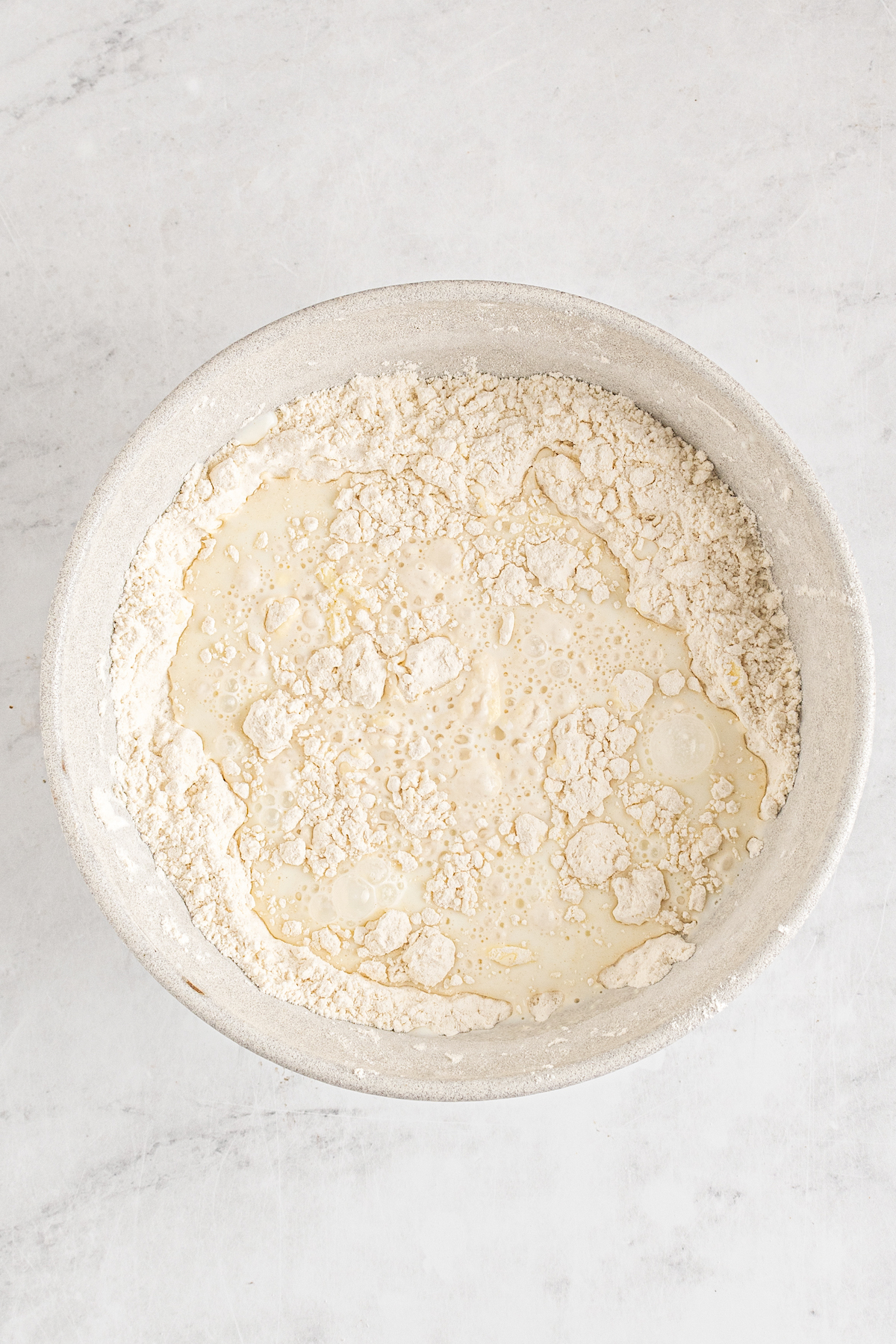 A bowl of unmixed biscuit dough ingredients.