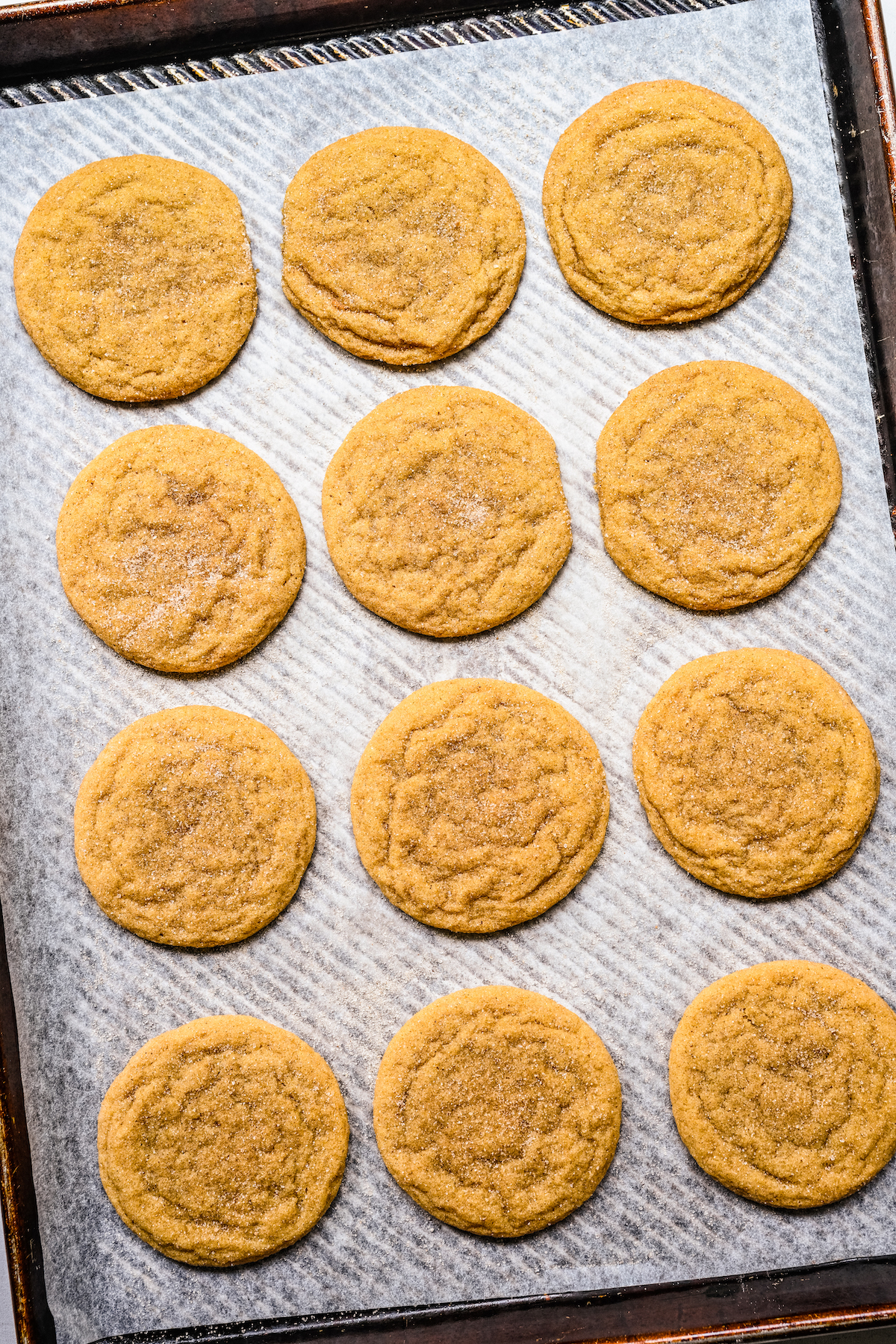 Baked maple snickerdoodles on a cookie sheet.