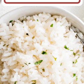 Puerto Rican Arroz Blanco in a white bowl with herbs on top.