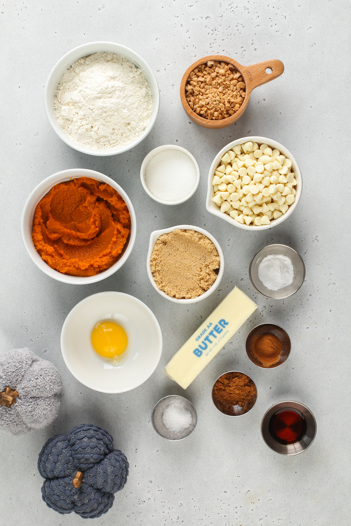 From top left: Flour, toffee bits, pumpkin puree, granulated sugar, white chocolate chips, brown sugar, baking soda, egg yolk, butter, salt, spices, vanilla.