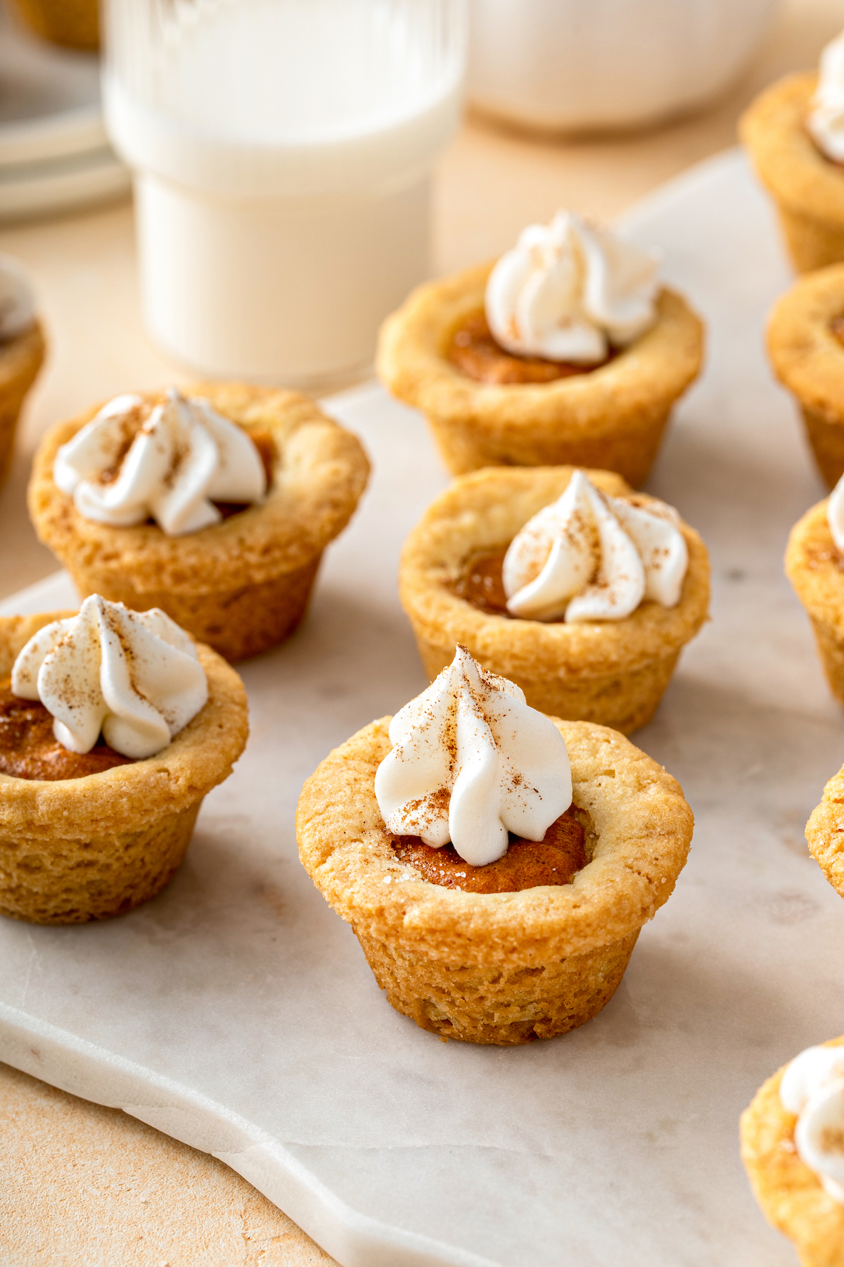 Pumpkin pie cookies lined up on a scalloped cutting board.