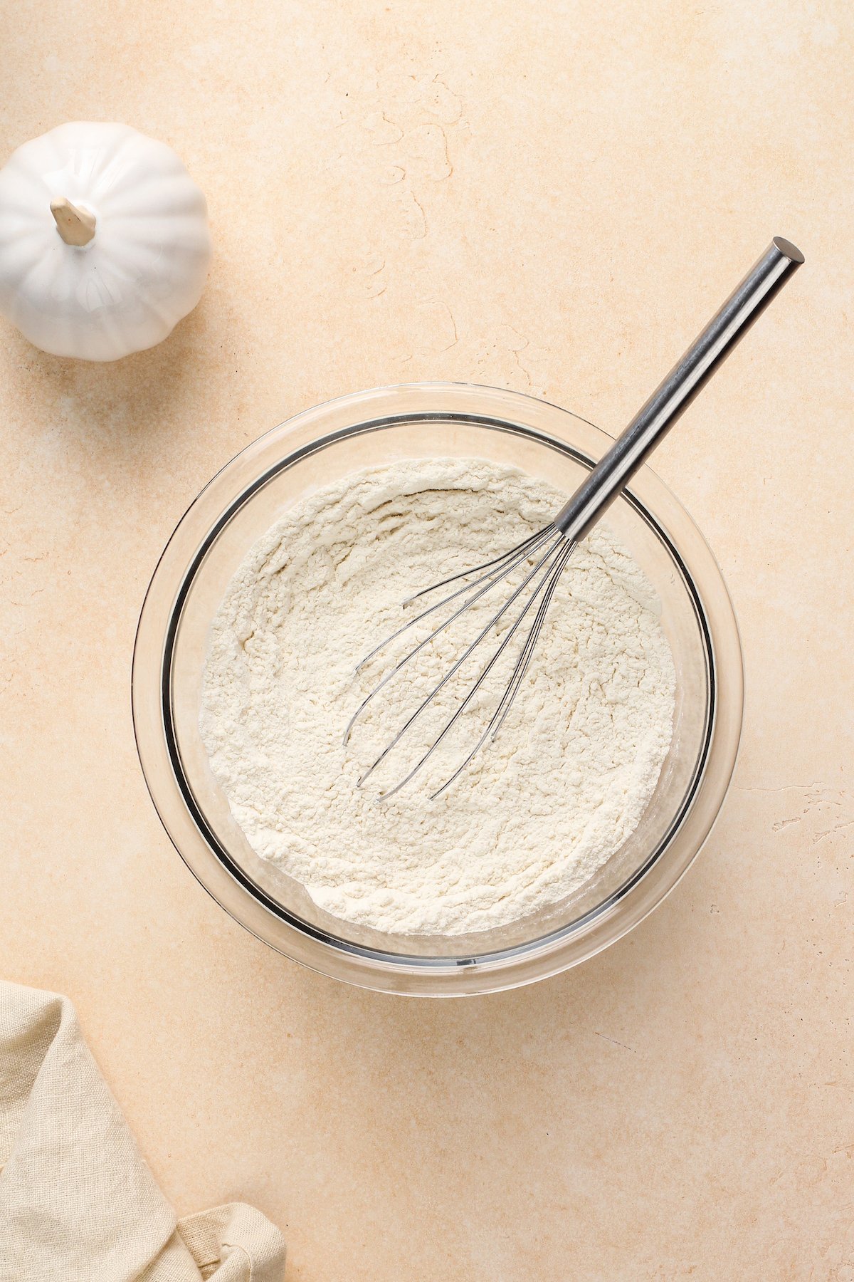 Dry sugar cookie ingredients in a mixing bowl with a whisk.