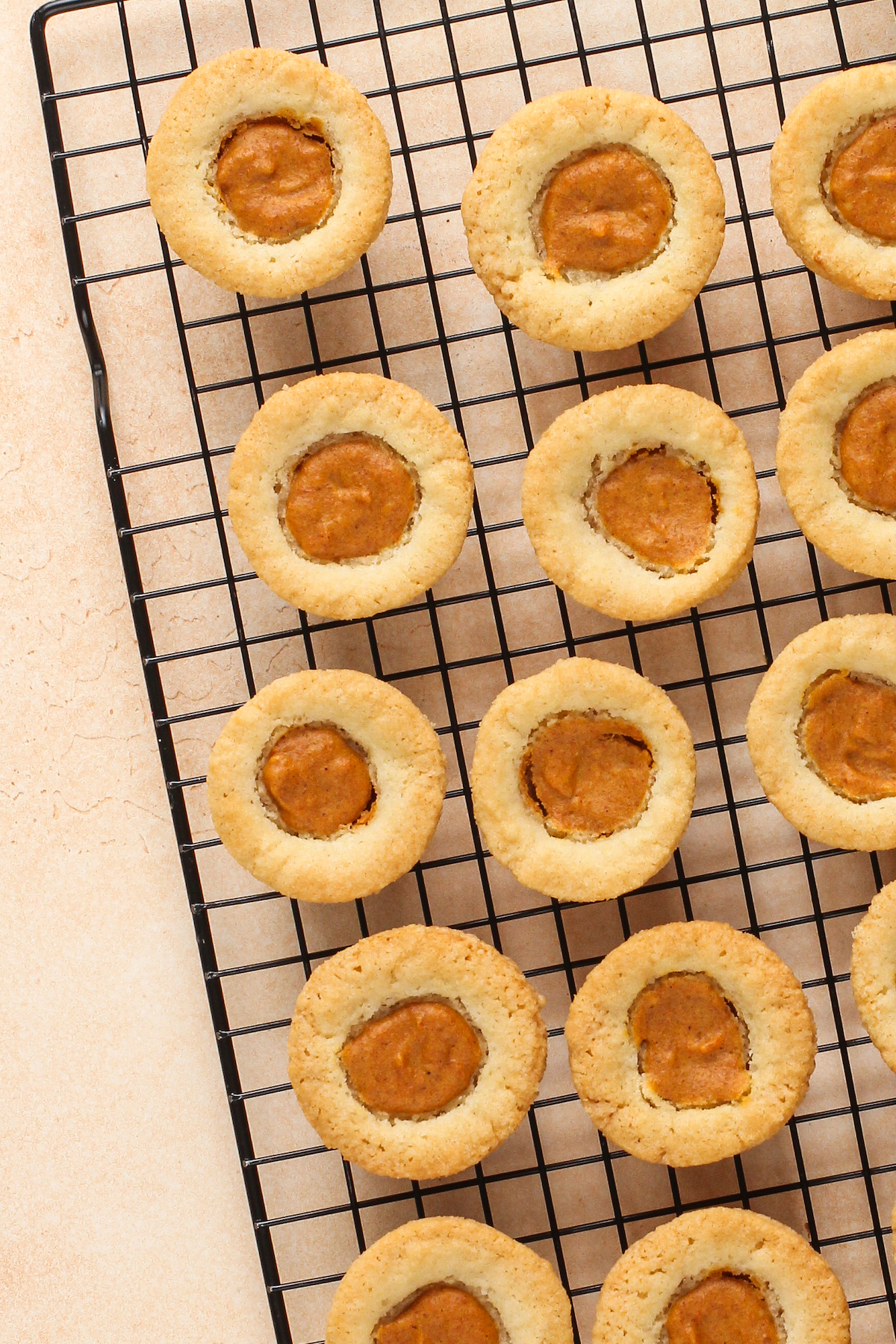 Baked pumpkin pie cookies cooling on a rack.