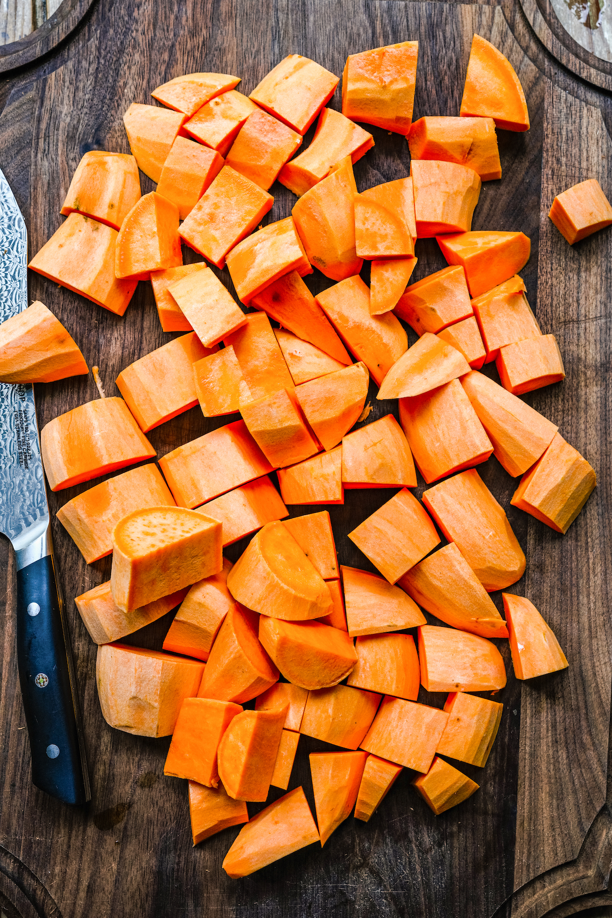 Peeled and cubed sweet potatoes on a cutting board.
