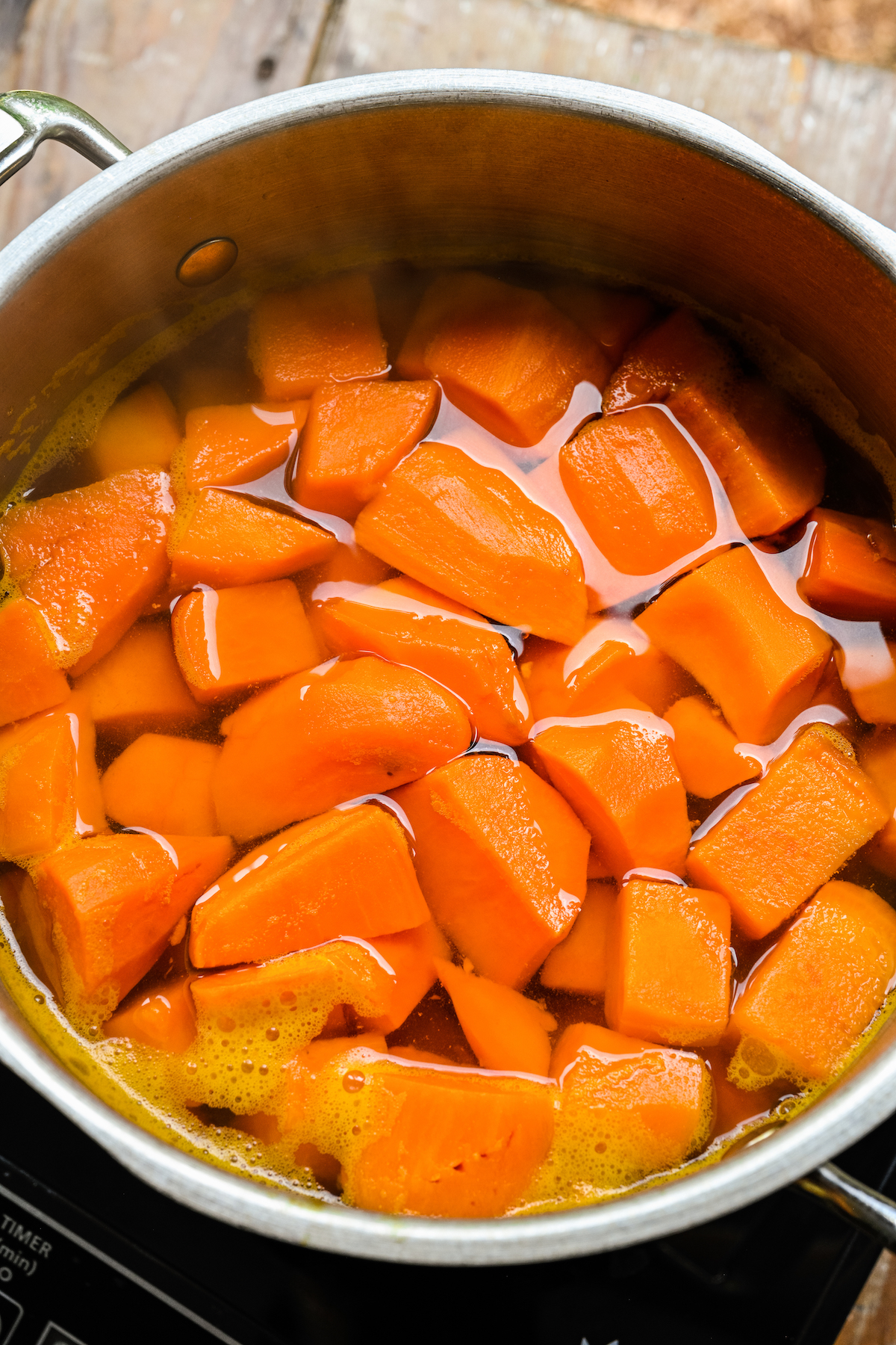 Peeled, cubed sweet potatoes simmering in a pot.