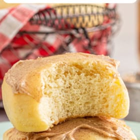 Two rolls stacked on top of each other with cinnamon honey butter.