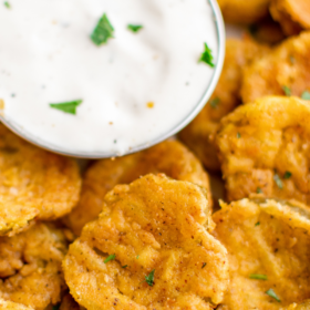 Fried pickles with a bowl of ranch dressing.