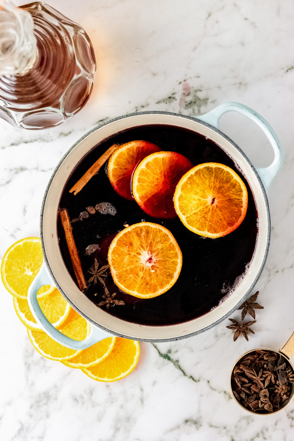 Adding the oranges and spices into the pot.