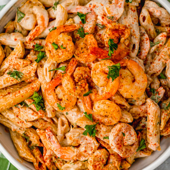 A bowl of penne pasta in creamy sauce with shrimp.