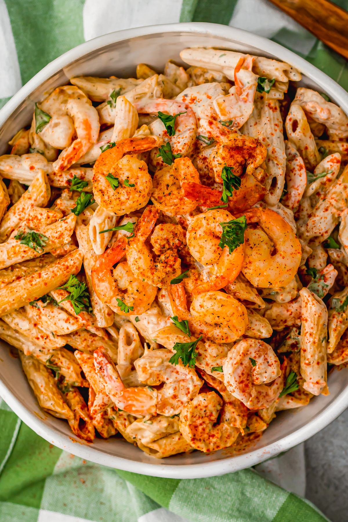 A bowl of penne pasta in creamy sauce with shrimp.