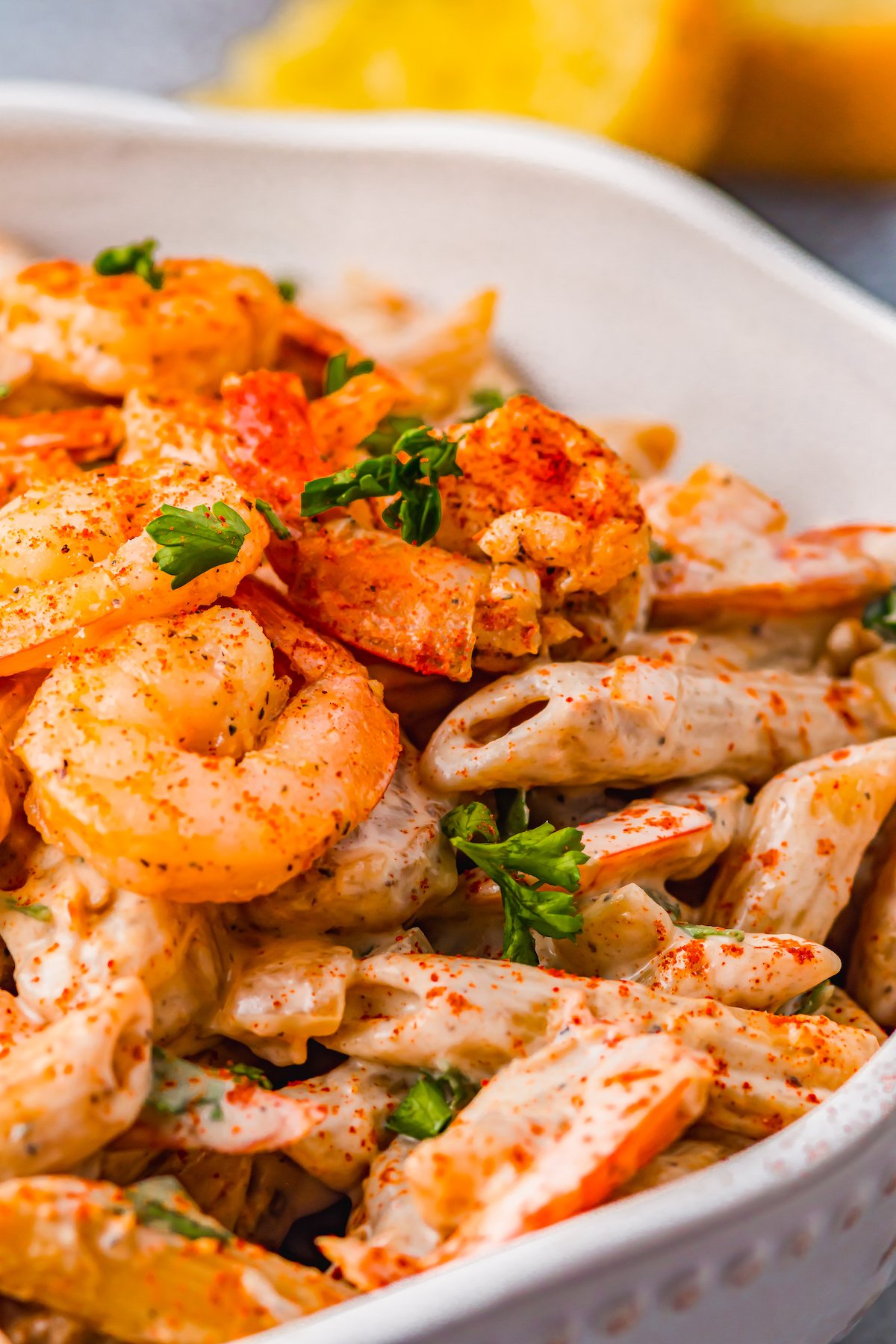 Cajun shrimp pasta in a white bowl with a scalloped edge.