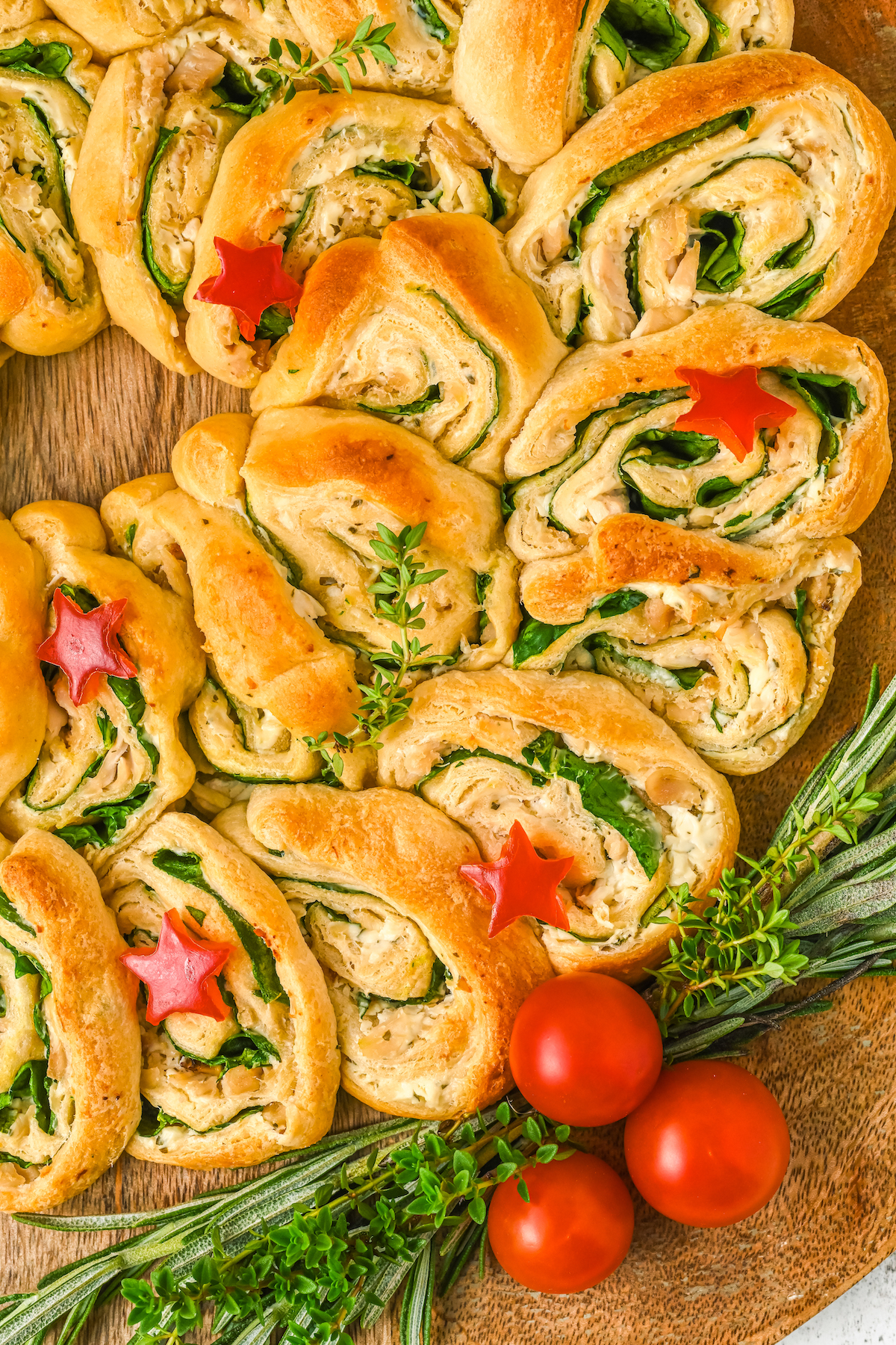 Close-up shot of crescent roll dough shaped into pinwheels with cheesy fillng.